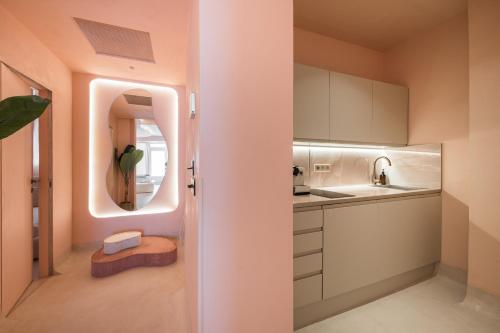 - une petite cuisine avec un évier et un miroir dans l'établissement Le Boudoir Iconic 4 guests Cannes, à Cannes