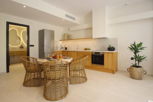 a kitchen with a table and chairs in a kitchen at Pnoe Villas Syros in Megas Yialos-Nites