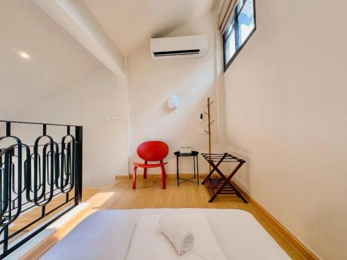 a bedroom with a bed and a red chair at The Walden Khaoyai in Mu Si