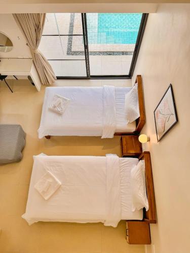 two beds in a room with a window at The Walden Khaoyai in Mu Si