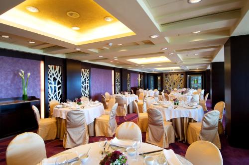 a banquet room with white tables and chairs at Grand Coloane Resort in Macau