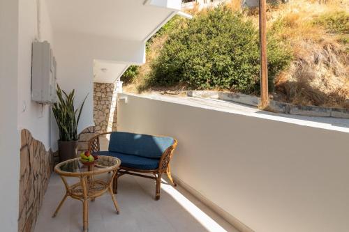 a balcony with a chair and a table and a window at Christina's Apartment in Afantou