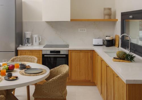 a kitchen with a table and a counter top at Pnoe Villas Syros in Megas Yialos-Nites
