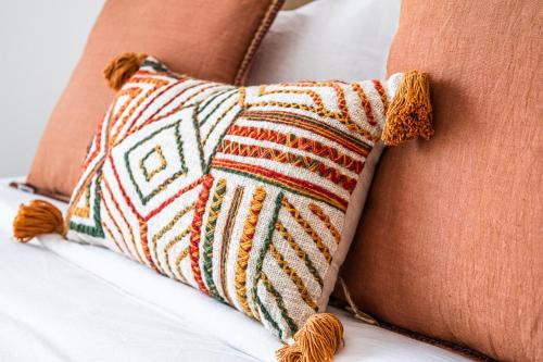 two pillows on a bed withcoordinylinylinylinylinylinylinylinyl at Voyage Waters Edge Studio With Canal Views in Yas Island