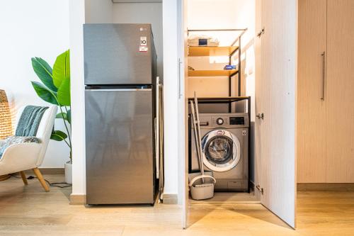 a refrigerator and a washing machine in a room at Voyage Waters Edge Studio With Canal Views in Yas Island