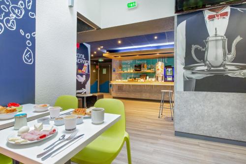 a restaurant with a table with plates of food on it at ibis budget Cavaillon in Cavaillon