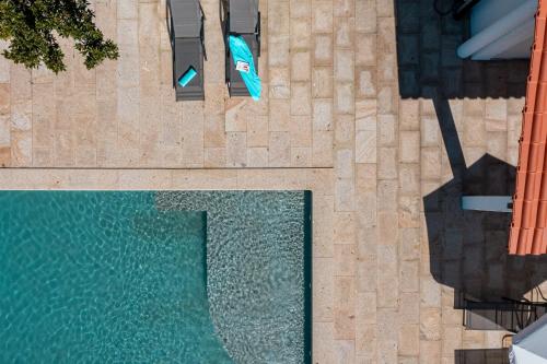 an overhead view of a swimming pool with chairs and a towel at Villa Aqua Madalena by MP in Madalena
