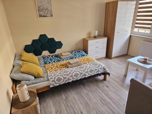 Un dormitorio pequeño con una cama y una cómoda. en Lubela, en Kołobrzeg