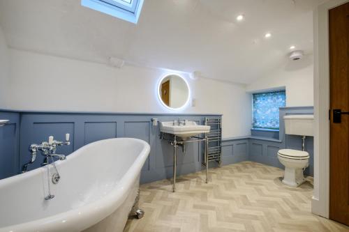 a bathroom with a tub and a sink and a toilet at Corner House in Ambleside