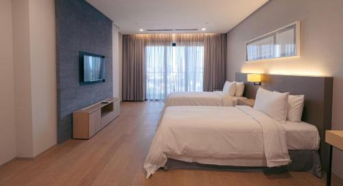 a hotel room with two beds and a television at Sfera Residence Kuala Lumpur City Centre in Kuala Lumpur