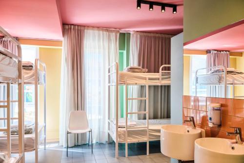 a room with bunk beds and a bathroom with a sink at Loop INN Hostel Santiago de Compostela in Santiago de Compostela