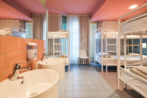 a bathroom with two bunk beds and a sink at Loop INN Hostel Santiago de Compostela in Santiago de Compostela