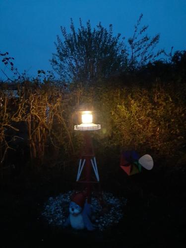 a light with a dog sitting next to it at Ferienhaus Menkhoff in Dornumersiel