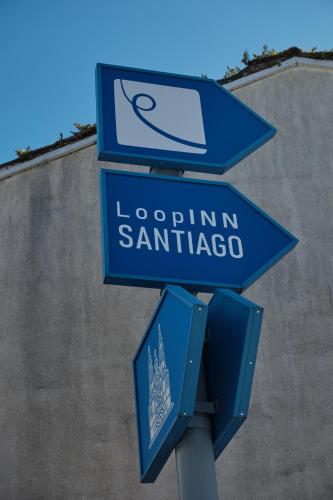 two blue street signs on top of a pole at Loop INN Hostel Santiago de Compostela in Santiago de Compostela