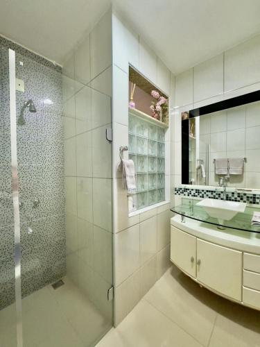 a bathroom with a glass shower and a sink at Pousada Familiar Vilage Bed & Breakfast Homestay in Volta Redonda