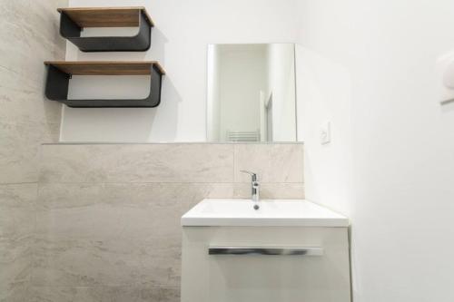 une salle de bain avec un lavabo blanc et un miroir dans l'établissement T3 spacieux avec terrasse et parking privatif, à Saint-Étienne