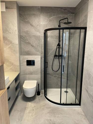 a bathroom with a shower and a toilet at Apartament BRYZA Marina Borki in Augustów