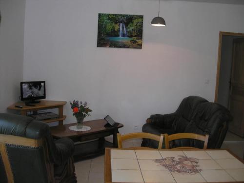 un salon avec deux chaises et une table dans l'établissement Maison accueillante à Saint-Martin-de-Boubaux, jardin agréable, à Saint-Martin-de-Boubaux