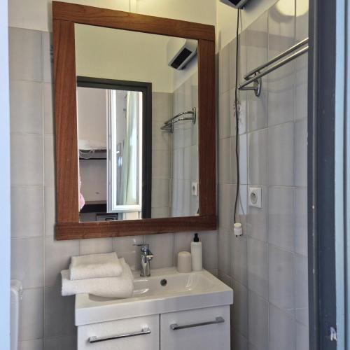 a bathroom with a sink and a mirror at Hôtel La Petite Bohème in Le Lavandou