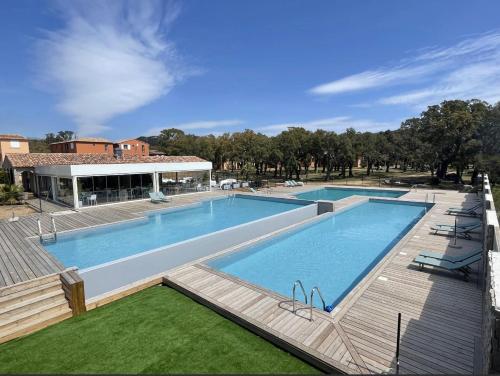a large swimming pool next to a wooden deck at Appartement 32 - Résidence les Hameaux de Saint Cyprien in Lecci