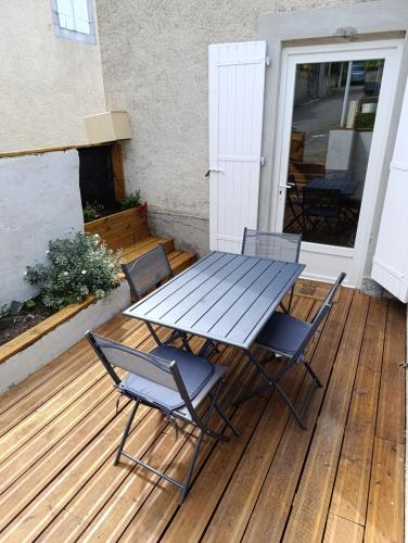 - une table de pique-nique et des chaises sur une terrasse en bois dans l'établissement La Maisonnette, à Lugagnan