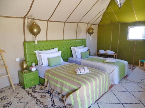 a bedroom with two beds in a tent at Your Desert Stay in Merzouga