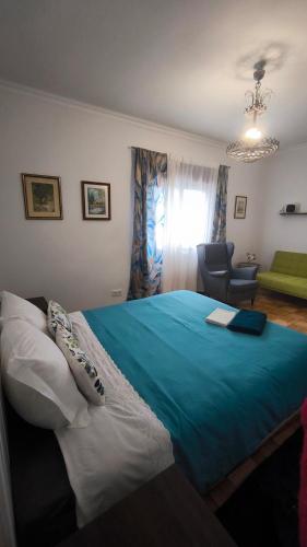 a bedroom with a large bed with a blue blanket at Casa da Rosa in Arcozelo