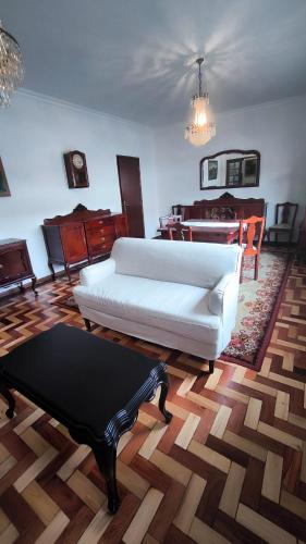 a living room with a white couch and a table at Casa da Rosa in Arcozelo