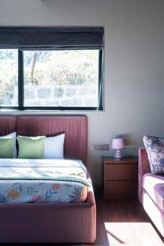 a bedroom with a bed and a window at StayVista at Barkat Villa with Jacuzzi in Rāmgarh