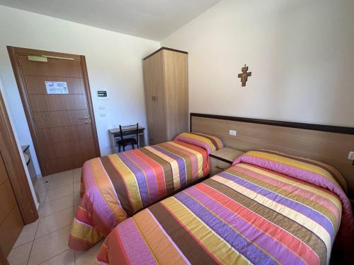 a bedroom with two beds and a cross on the wall at Casa di Ospitalità religiosa San Francesco d'Assisi - BA in Bari