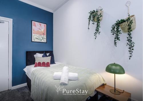 a bedroom with a bed with blue walls at BIG House for Business Stays in Barnsley with 6-bedrooms & 8 Beds by PureStay in Barnsley