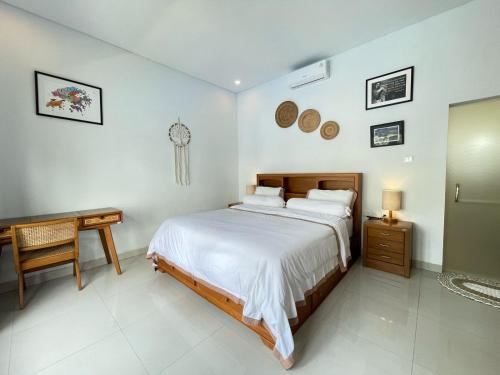 a bedroom with a bed and a desk and a clock on the wall at Ananda Villa Yeh Gangga by The Lavana - 4 Bedroom Villa with Private Pool in Krambitan