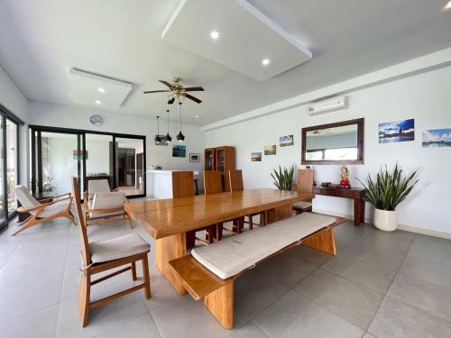 a dining room with a wooden table and chairs at Ananda Villa Yeh Gangga by The Lavana - 4 Bedroom Villa with Private Pool in Krambitan