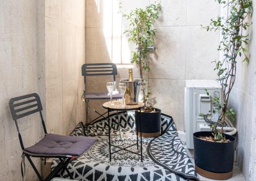 un patio avec deux chaises et une table avec des plantes dans l'établissement La Maison by Simone T2, à Cannes