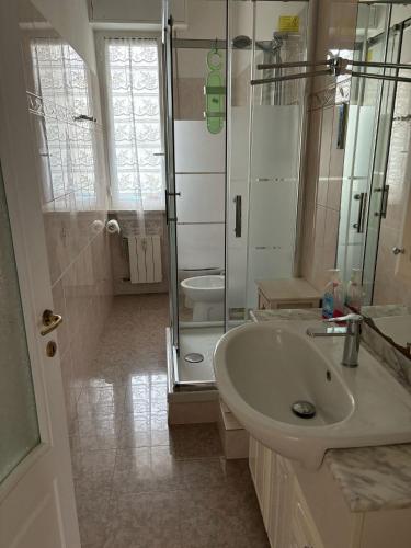 a white bathroom with a shower and a sink at Casa vacanze di Carla in Savona