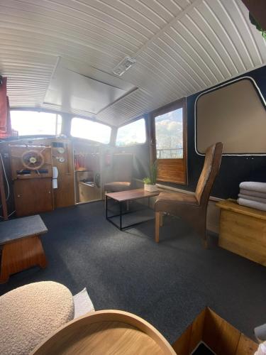 une vue d'une salle de train avec une table et des chaises dans l'établissement Les Pichies, Bateau insolite, Le Nathalie Nath, à Saint-Léger-sur-Vouzance