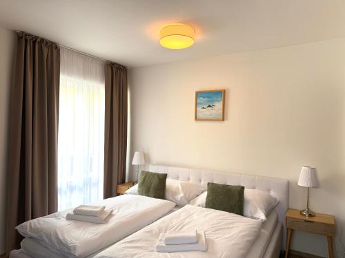 a large white bed in a room with a window at Penzion Raimund in Smokovce