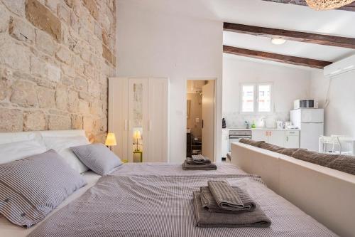 a bedroom with a large bed and a stone wall at Apartments Martinis in Vis