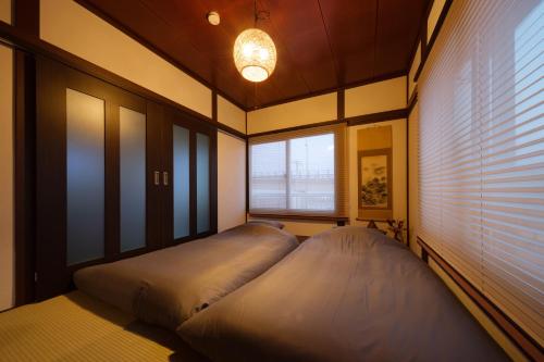 a large bed in a room with a window at 小田原シーサイドハウス in Odawara
