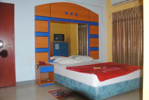 a bedroom with a large bed with a wooden headboard at Hotel Sea Alif in Cox's Bazar