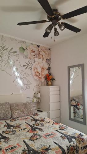a bedroom with a bed and a ceiling fan at Apartamento con encanto in Torredembarra