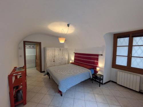a bedroom with a bed with a red and white blanket at Casa Pievani - Bernina Express in Tirano