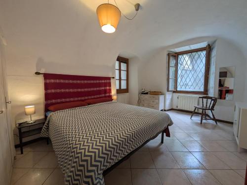 a bedroom with a bed with a red pillow at Casa Pievani - Bernina Express in Tirano