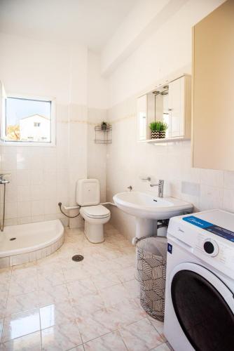 a bathroom with a sink toilet and a washing machine at Giannis Holiday House 2 in Vitalades