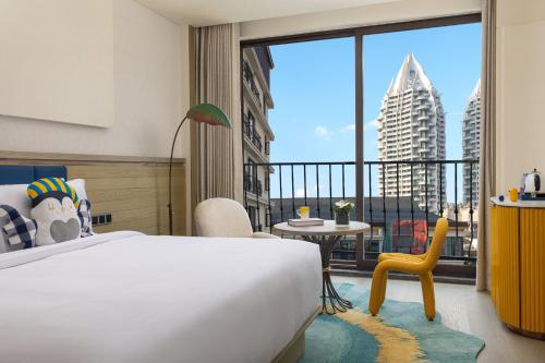 a bedroom with a bed and a balcony with a view at voco Xishuangbanna Gaozhuang by IHG in Jinghong