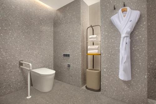 a bathroom with a toilet and a robe on a wall at voco Xishuangbanna Gaozhuang by IHG in Jinghong