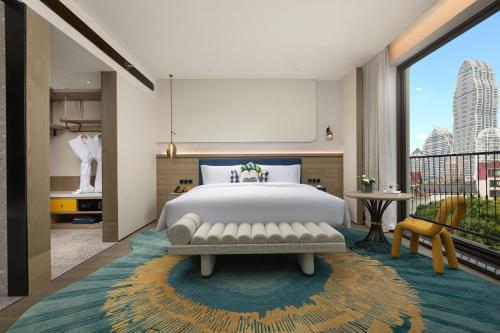 a bedroom with a large bed and a large window at voco Xishuangbanna Gaozhuang by IHG in Jinghong