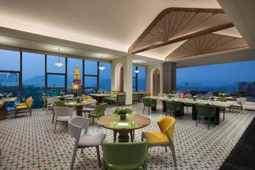 a restaurant with tables and chairs and views of the eiffel tower at voco Xishuangbanna Gaozhuang by IHG in Jinghong