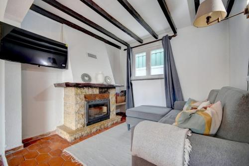 a living room with a couch and a fireplace at Murches' House in Alcabideche