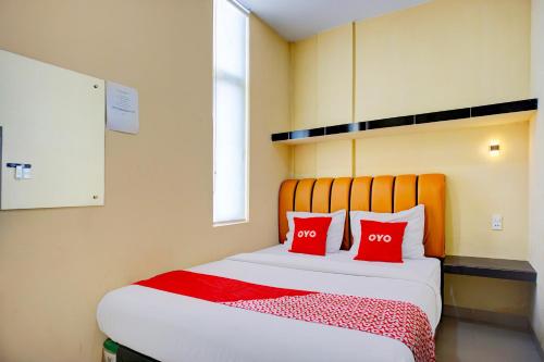 a bedroom with a bed with two red pillows at Dancenter Helvetia Near Plaza Millenium Formerly Sunny Inn in Medan